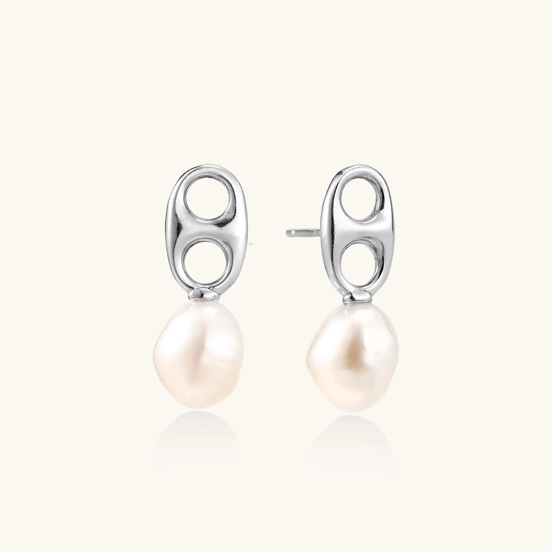 Sterling silver oval stud earrings with dual circular cutouts and suspended freshwater pearls on white background.