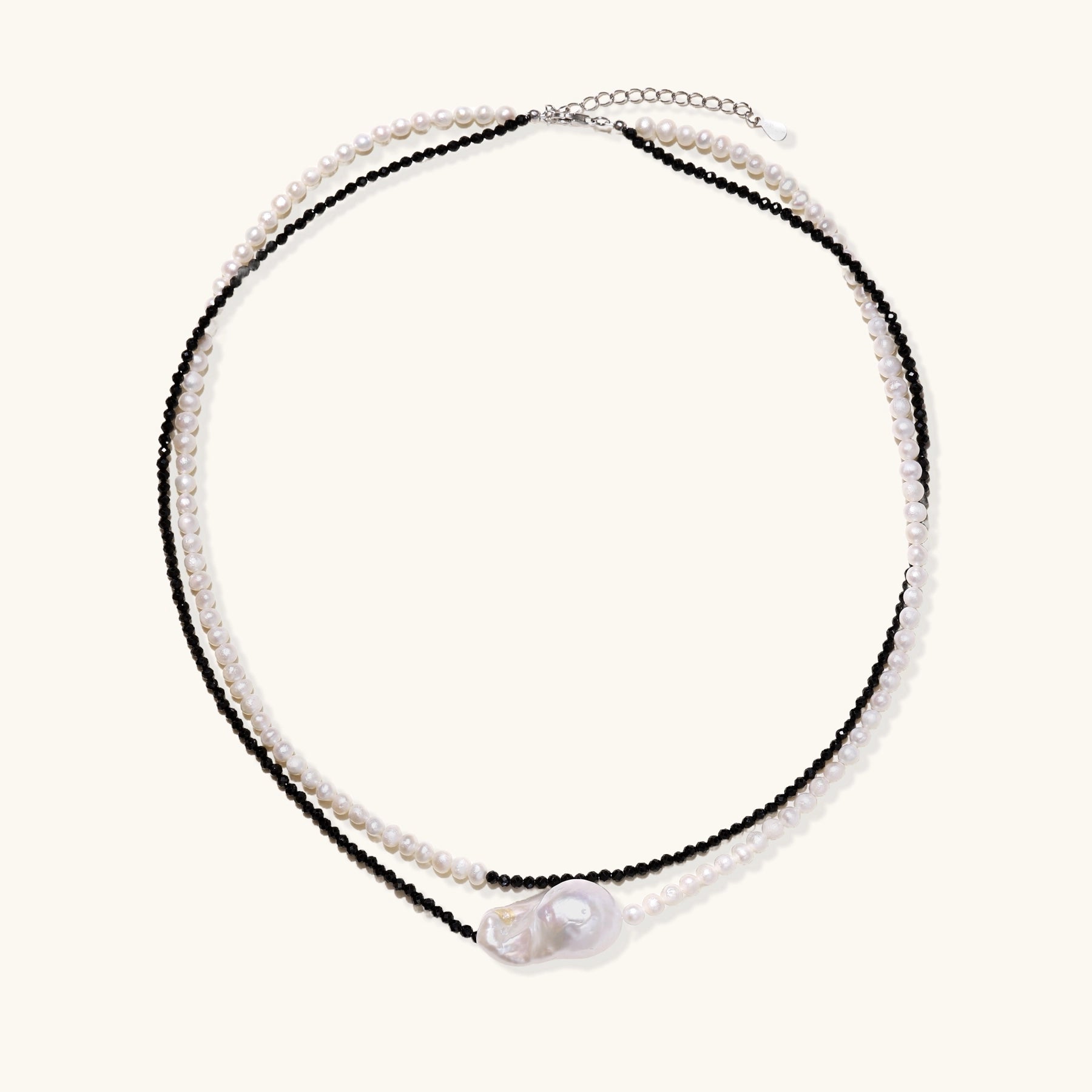 Two-strand necklace with black crystal beads and white pearls featuring a large baroque pearl centerpiece on white background.