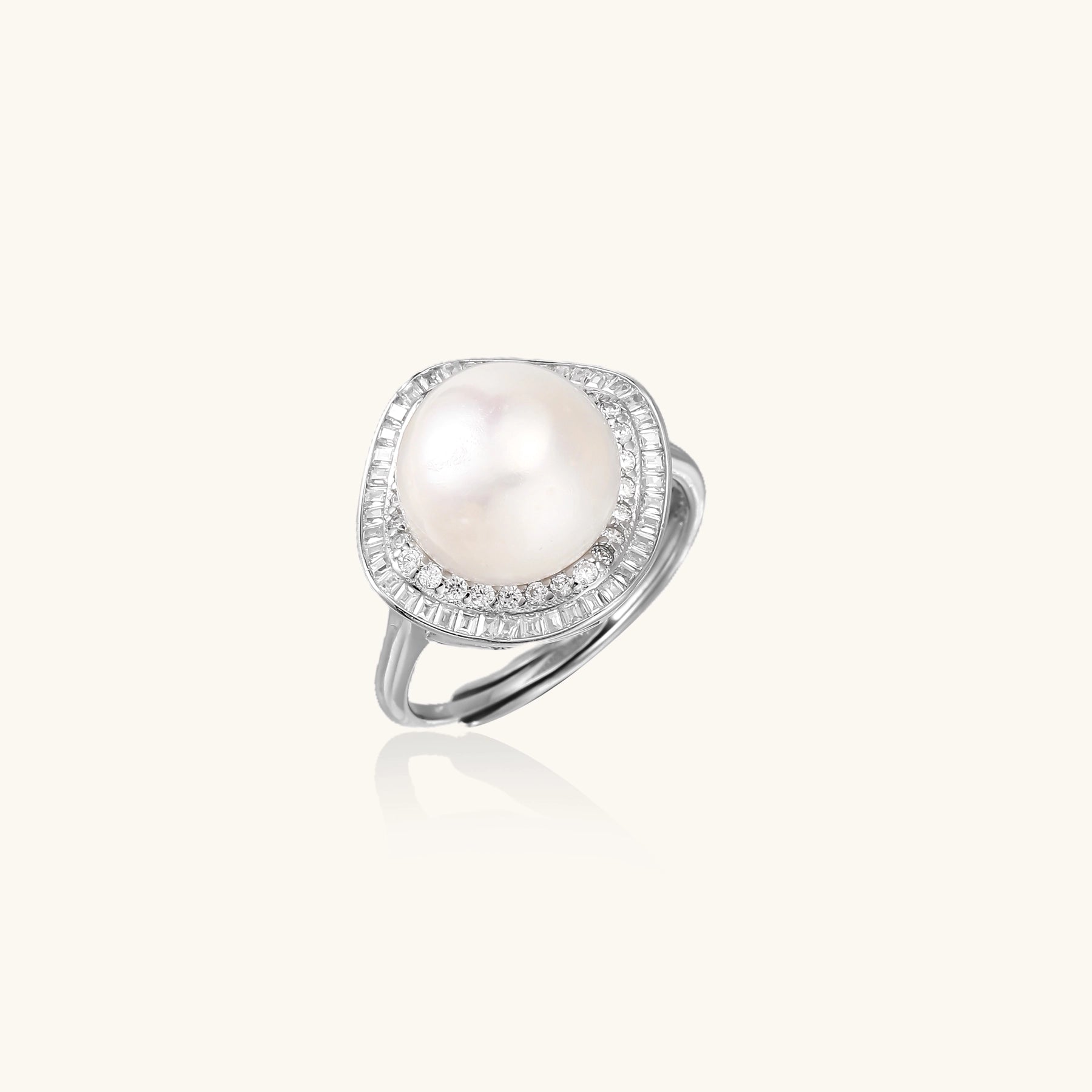 Sterling silver ring with 11mm freshwater pearl surrounded by double diamond halo on white background.
