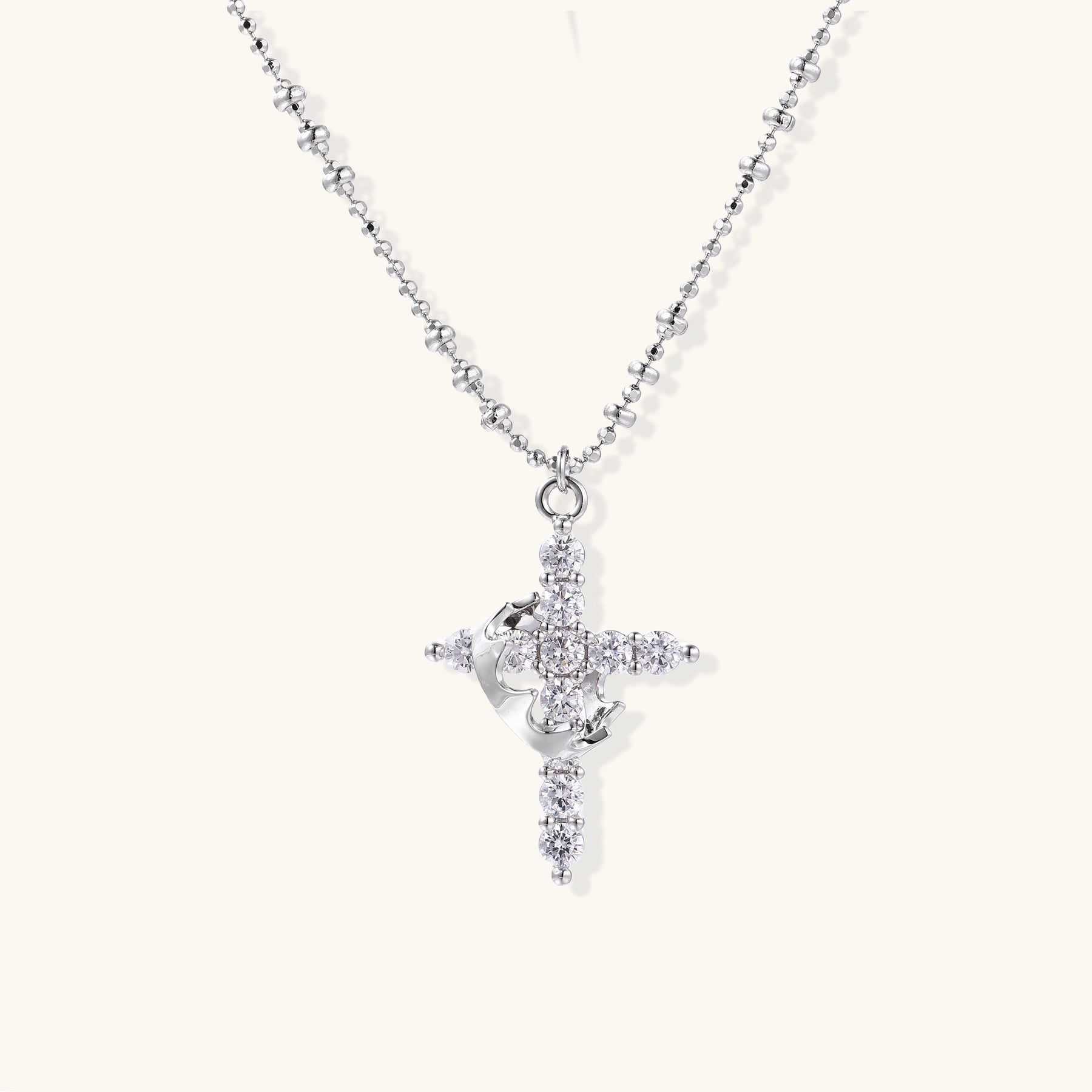Close-up of 18K gold plated cross necklace with zirconia crystals arranged in cross pattern on ball chain