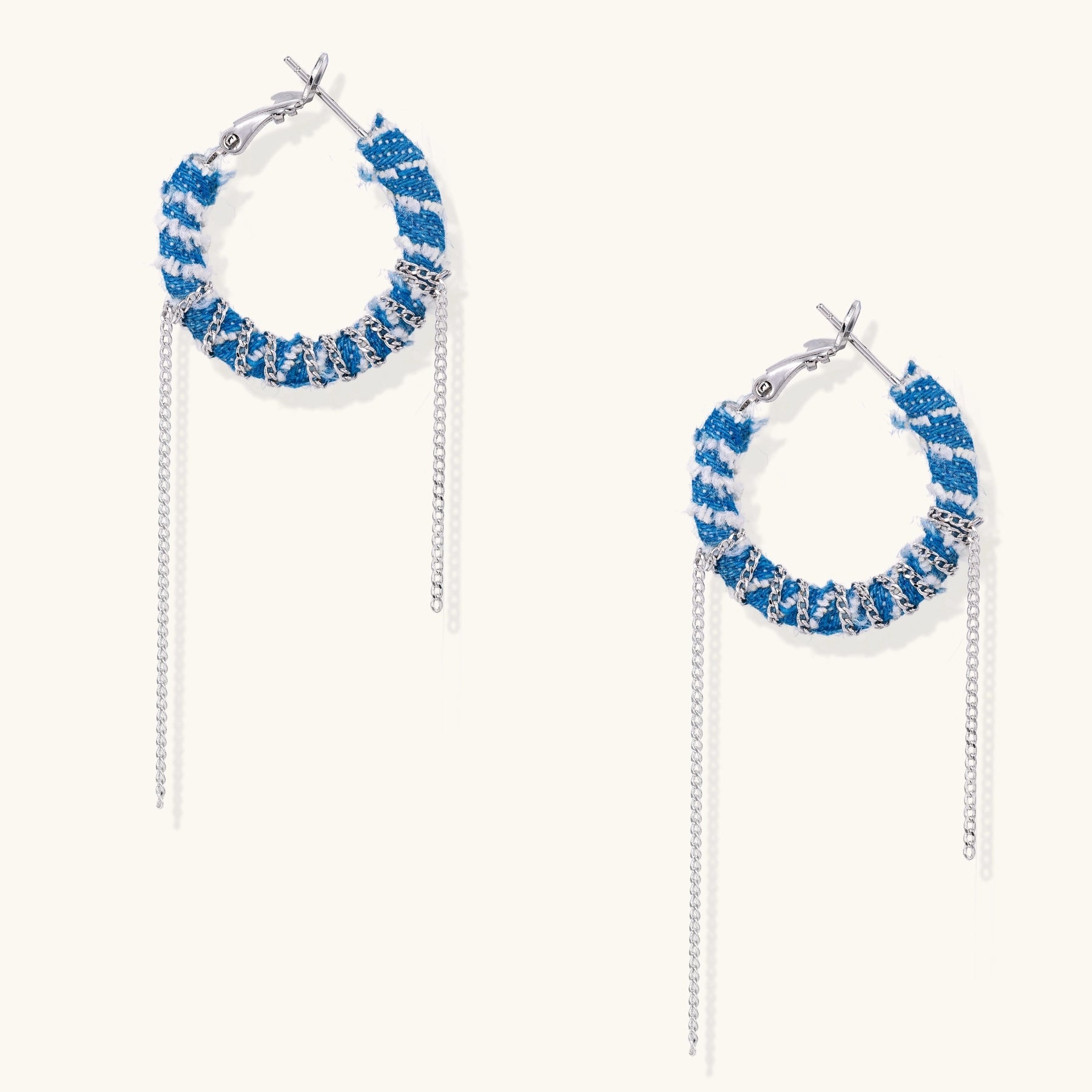 Blue and white checkered denim-wrapped hoop earrings with delicate silver chain dangles on neutral background