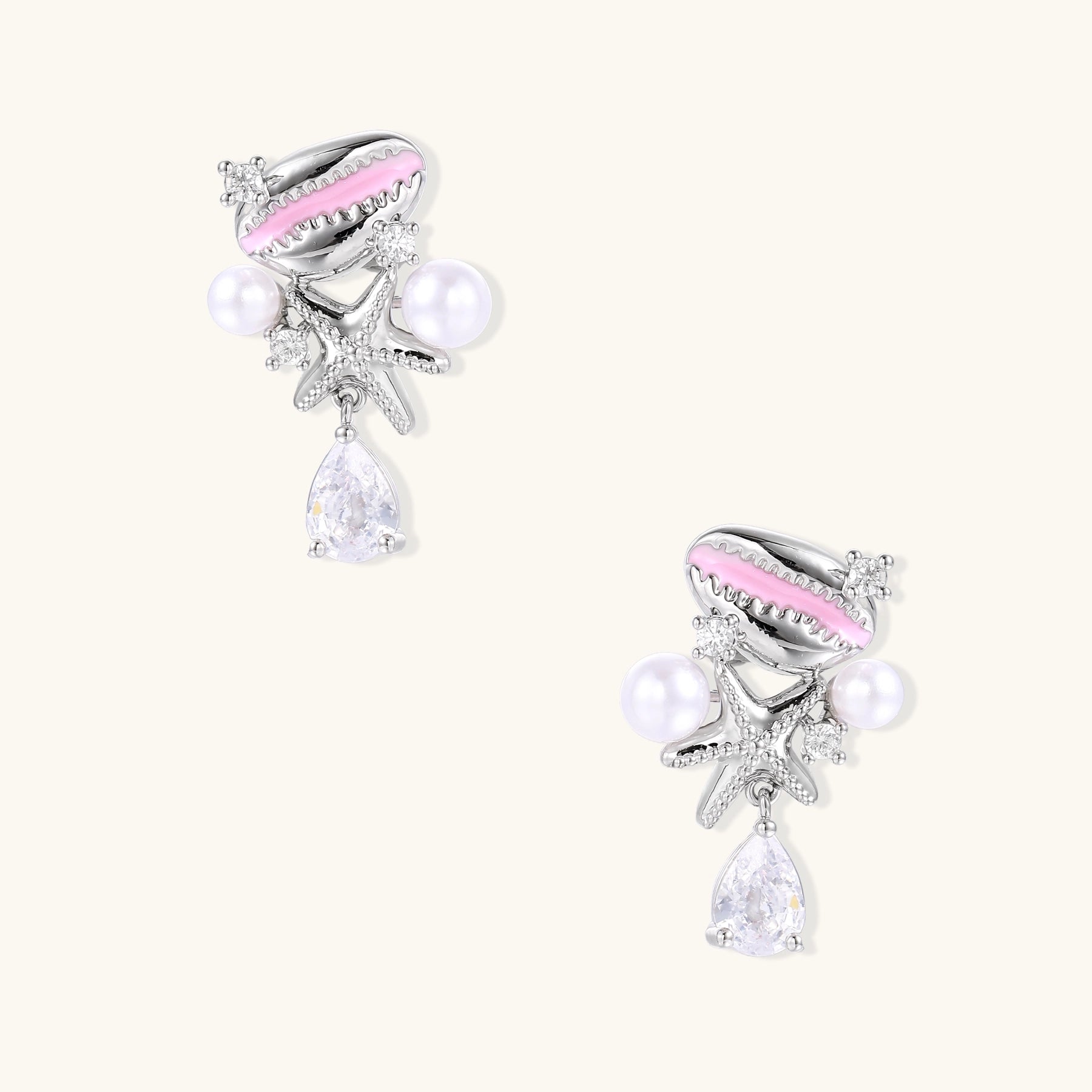 Gold-plated dangle earrings with enamel shell charms, white pearls, starfish accents, and crystal drops on white background.