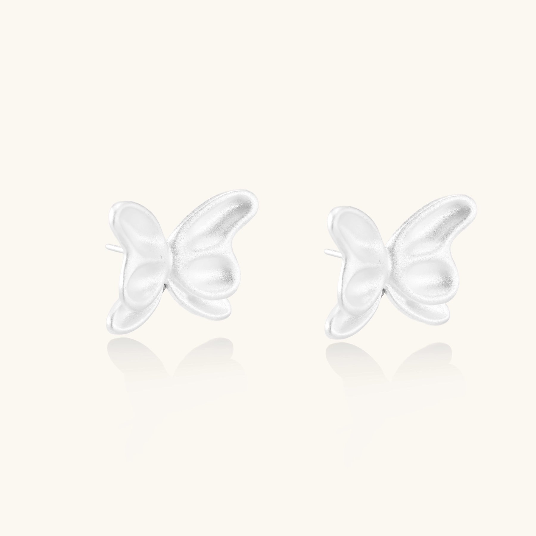 Delicate sterling silver butterfly stud earrings with intricate wing details on a neutral background.