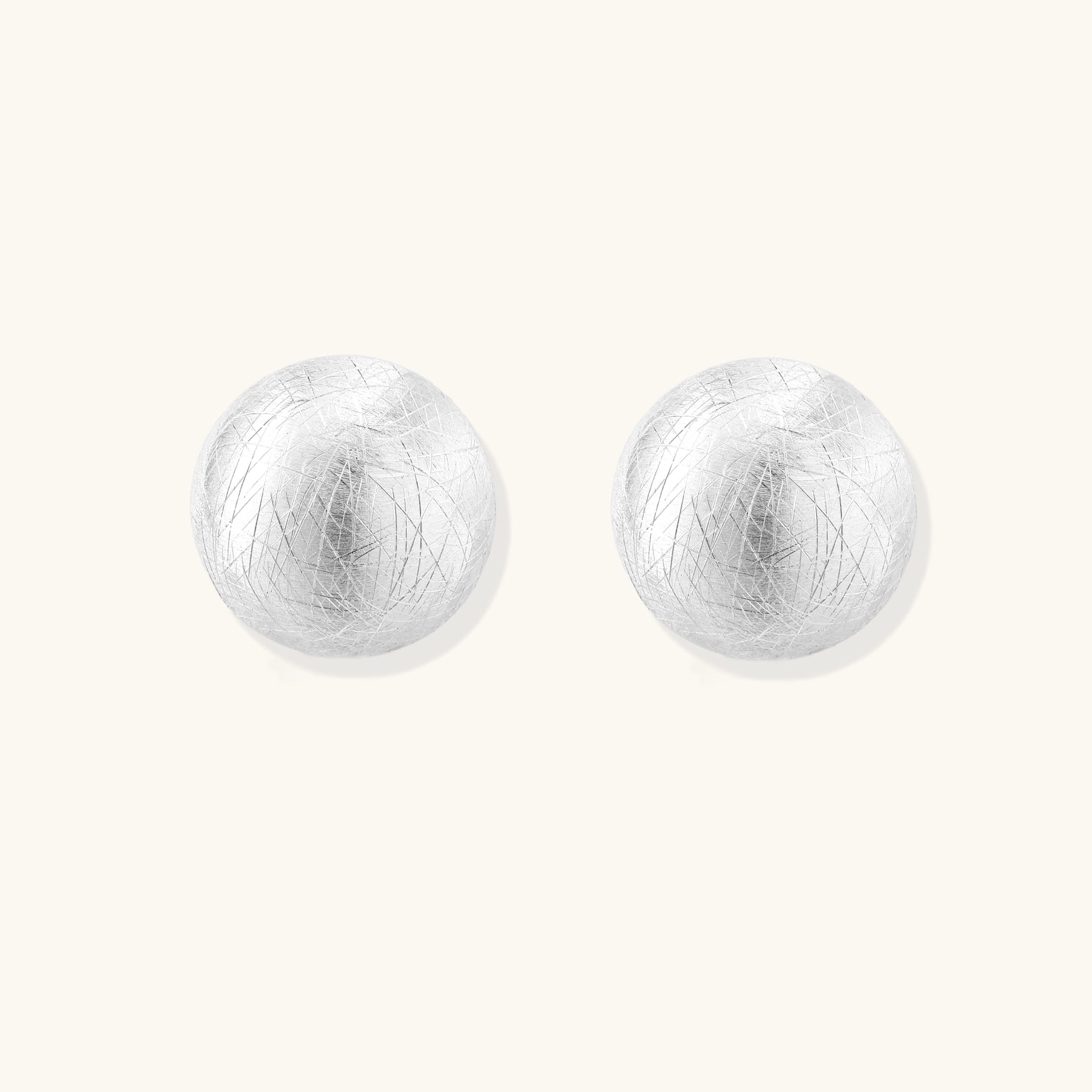 Brushed sterling silver dome-shaped stud earrings with textured surface and secure lever-back closure on white background.