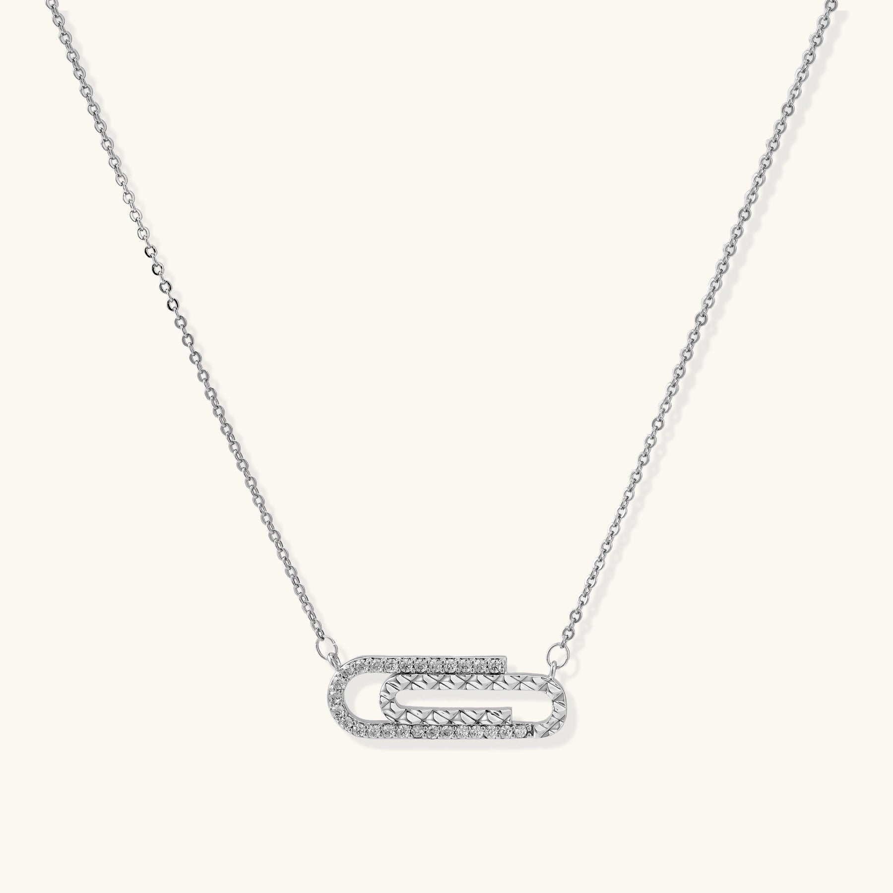 Delicate 14K gold plated chain necklace with crystal-accented carabiner-style pendant on white background