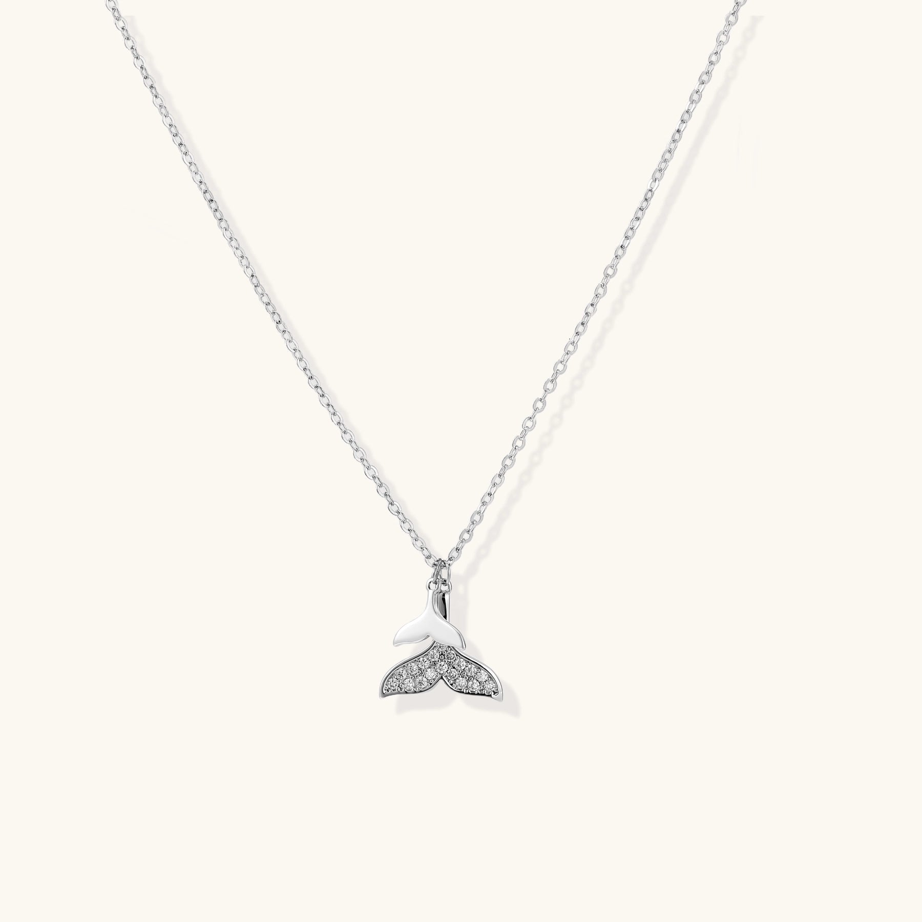 Delicate 14K gold-plated whale tail pendant necklace with sparkling crystal details on fine chain against white background.