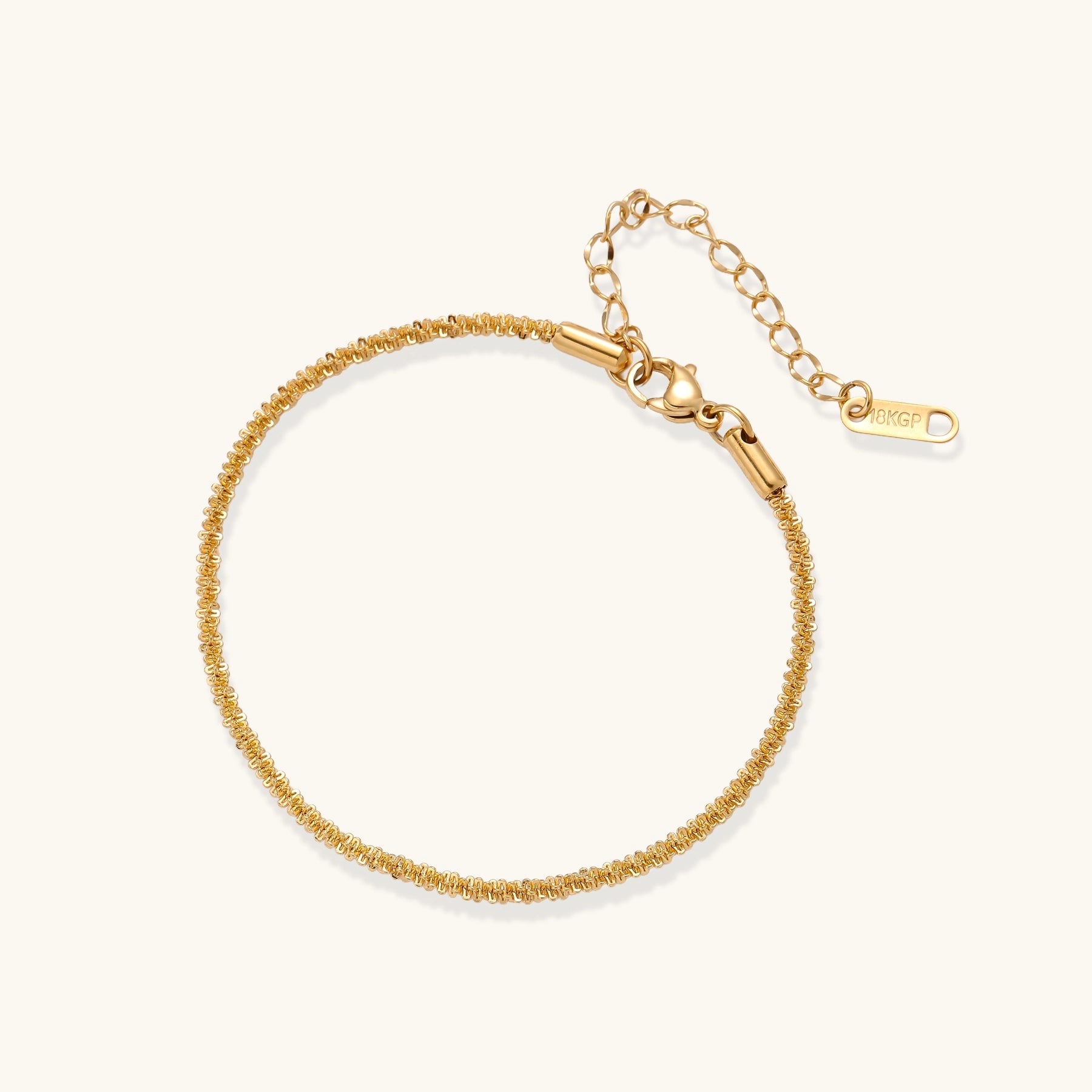 Delicate 18K gold plated stainless steel chain bracelet with textured links and adjustable extender on neutral background.